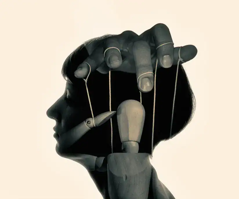 Artistic sculpture of a woman's profile with marionette strings and puppet hands.