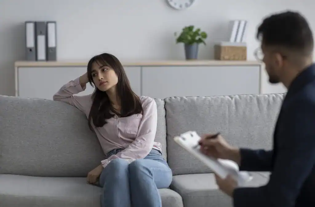 Young woman in therapy session appearing anxious and distressed.