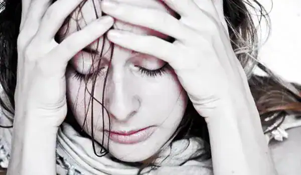 Woman with hands on her head, appearing stressed or overwhelmed.