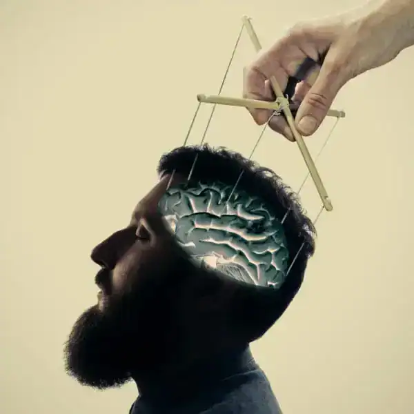 Conceptual image of a man with a brain model and a hand with a slingshot.