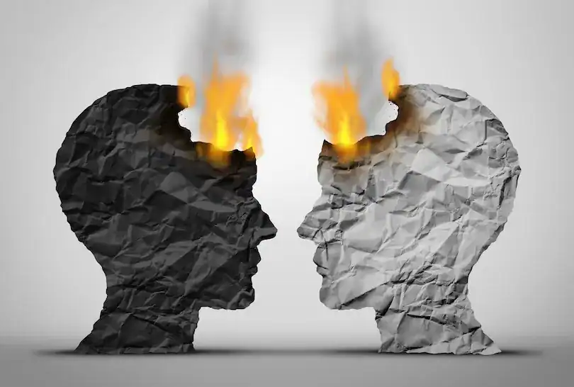 Two crumpled paper heads facing each other with flames inside the heads.